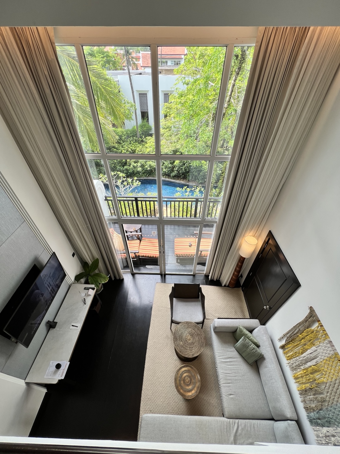 An upper-level view of a hotel living area with a tall window